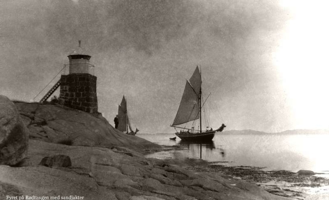 Fyret på Rødtangen med sandjakter. Foto: Thorleif Thoresen. Årstall ukjent. Fra slutten av 1800-tallet til langt innpå 1900-tallet fraktet flere hundre sandjakter sand fra morenene på begge sider av Svelvikstrømmen til kunder mest langs Oslofjorden.