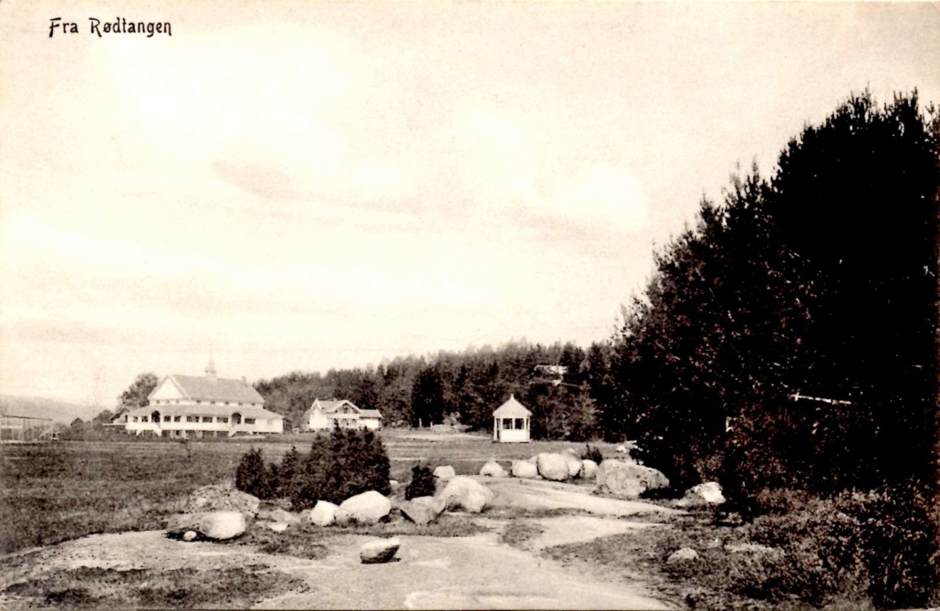 Rødtangen Hotel nede ved dampskipsbryggen var det eldste overnattingsstedet på Rødtangen. I 1912 ble det bygget et nytt hotell med kombinert restaurant og danselokale på jordet som noen kaller sletta i Rødtangen sentrum. Dette fotoet er tatt kort tid etter at det nye hotellet sto ferdig. Utgiver: Carl Normanns Kortforlag, Kristiania. Kortet er poststemplet 28.8.1915.