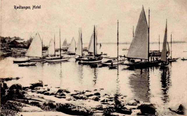 Seilbåter klargjøres for regatta i Rødtangen-bukten. Utgiver NS No. 102. Poststemplet Rødtangen 3.7.1912. Fra teksten: «Her er et deilig sted. Mangler kun ditt behagelige selskab.»