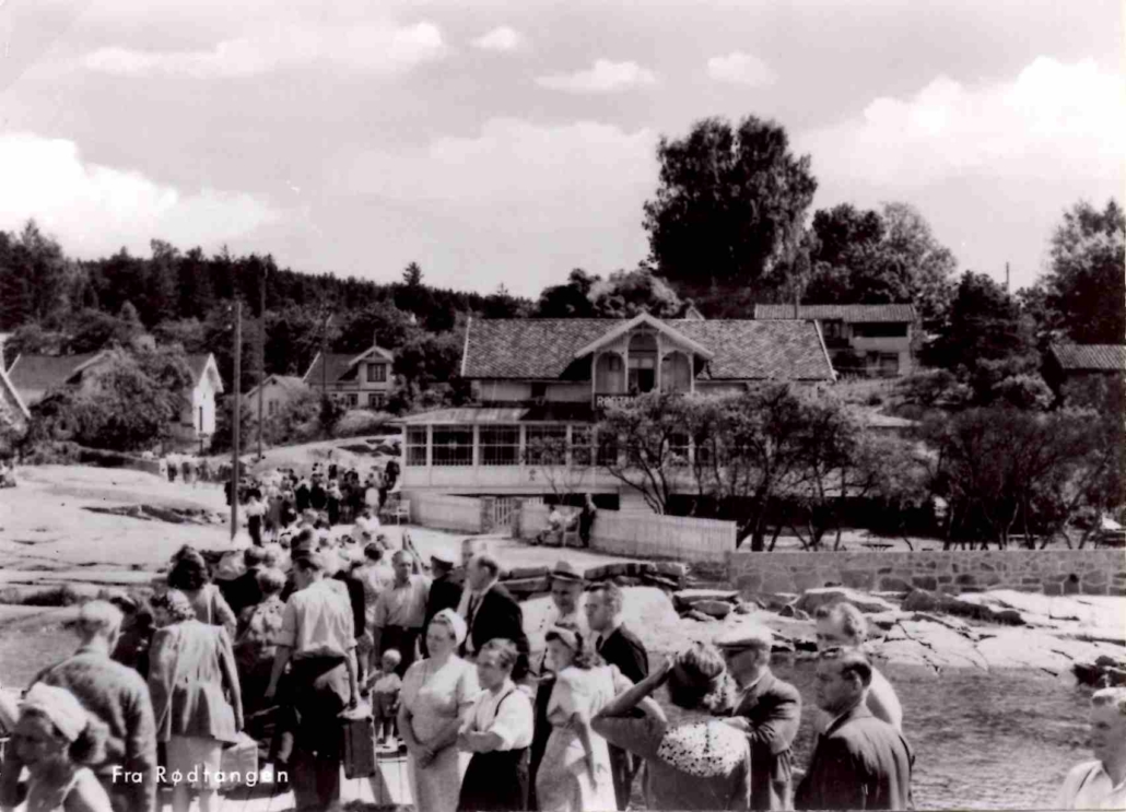 «Fra Rødtangen». Fotoet er fra 1950-tallet, og rutebåtene er fortsatt viktigste transportmiddel til og fra Rødtangen. På 1950-tallet var Rødtangen Bad blant annet Norsk Folkehjelps feriested for slitne husmødre, og på folkemunnet kalte noen det for "tynnslitten" - badet var også nokså nedslitt. Utgiver: K. Harstad Kunstforlag.